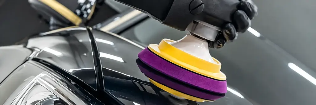 Polishing machine correcting automotive paint in an El Paso detailing shop