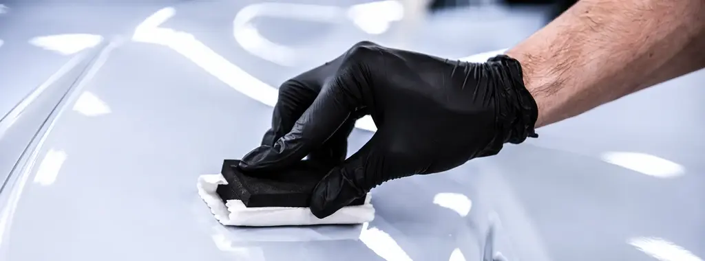 Ceramic coating applied to a vehicle by a gloved hand