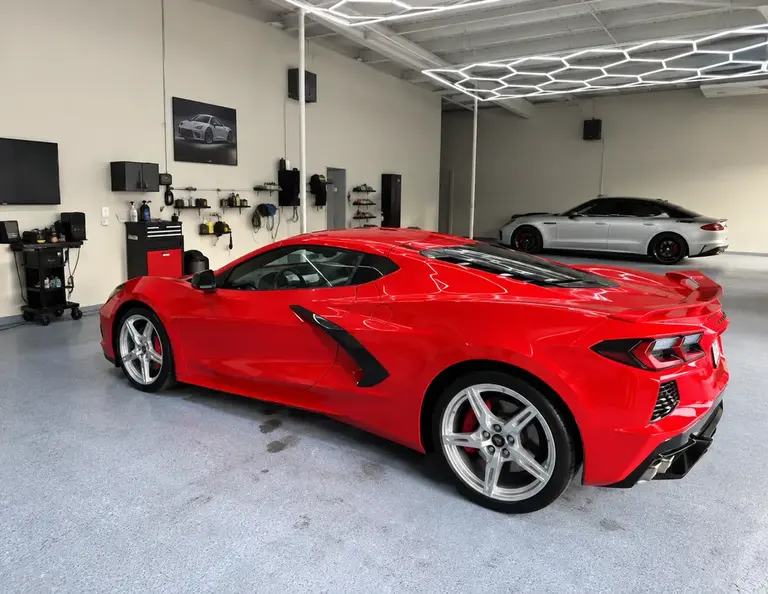 Red Chevrolet Corvette inside the Reality Auto Detailing shop
